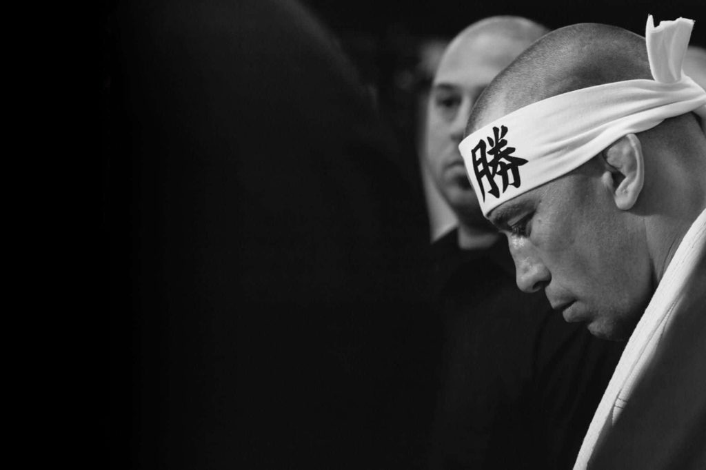 Greyscale profile of MMA legend Georges St-Pierre with victory headband and focused expression Wallpaper