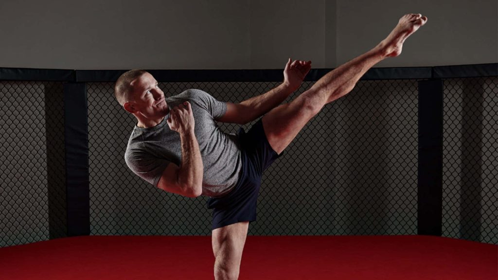 Georges St-Pierre powerful high kick in MMA octagon red mat dynamic martial arts wallpaper