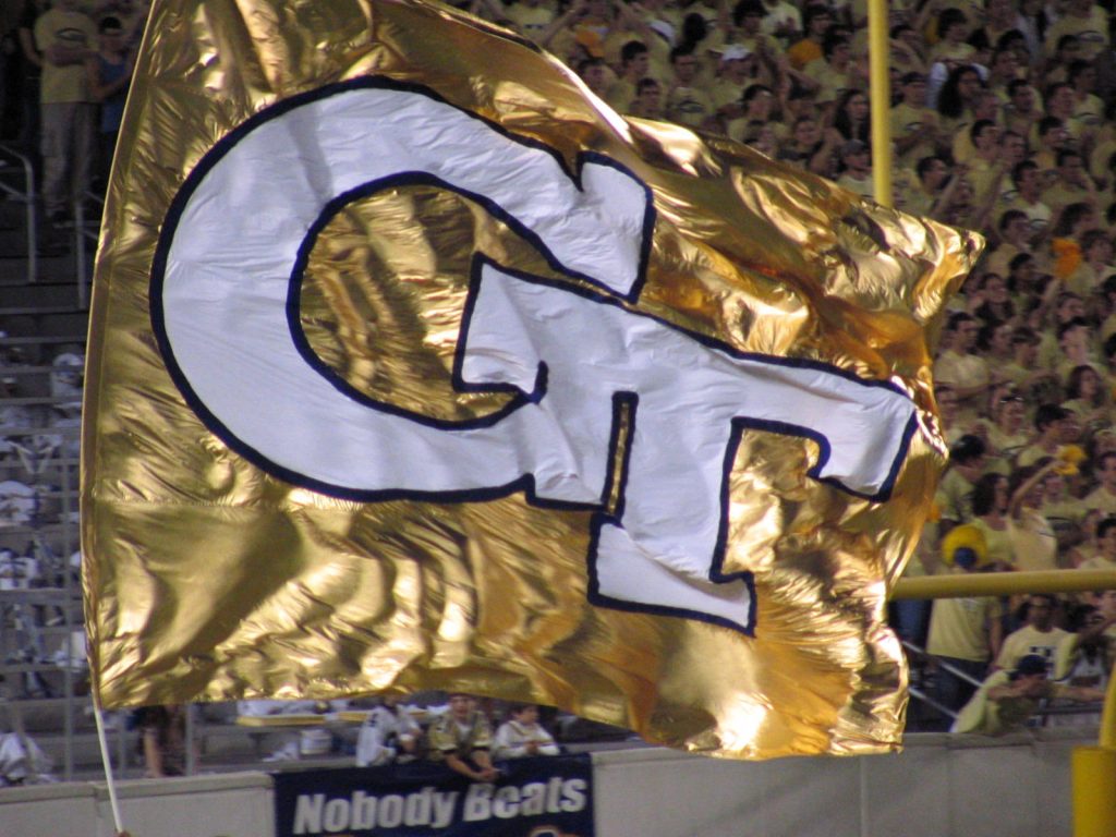 Georgia Tech gold flag waving over cheering football crowd vibrant Yellow Jackets wallpaper