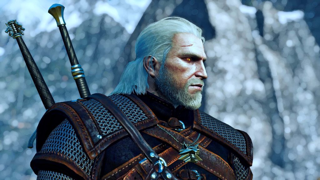 Geralt of Rivia in detailed armor with glowing eyes and wolf medallion in snowy mountains Wallpaper