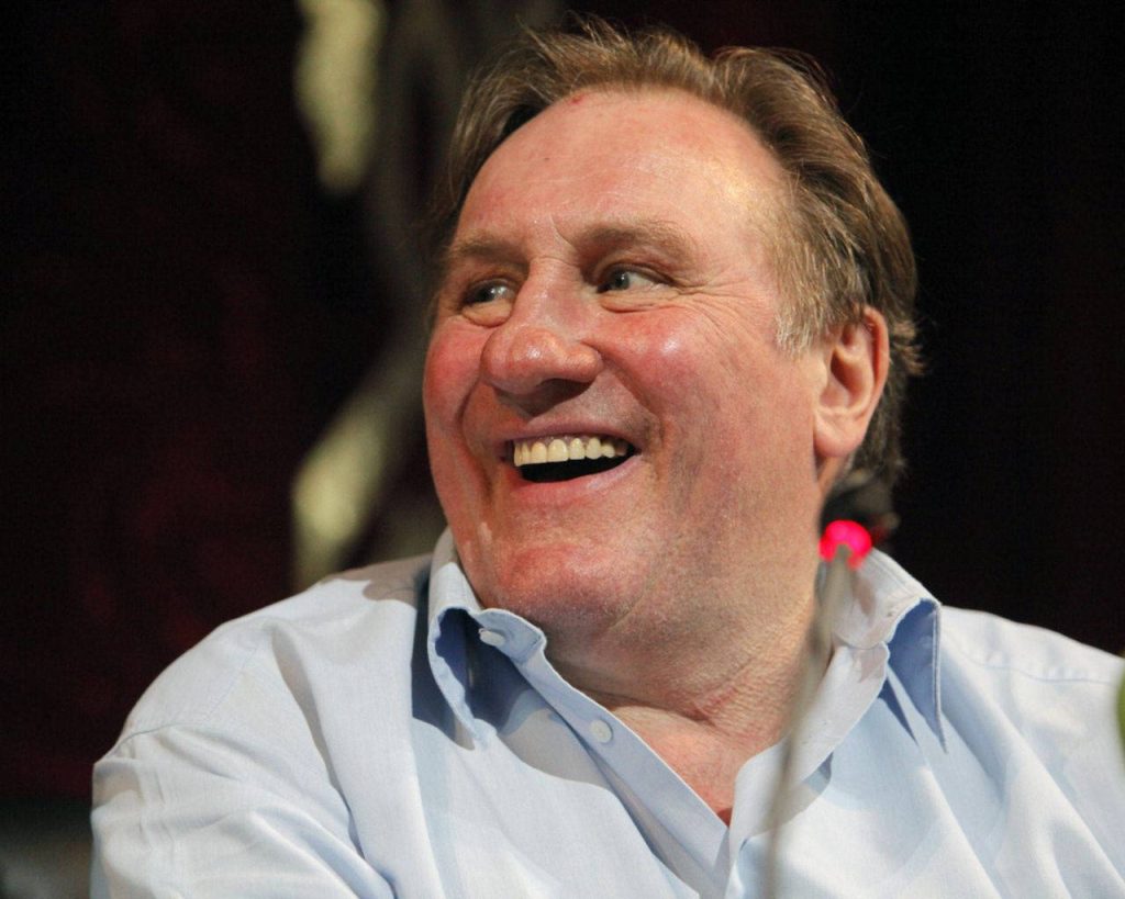 Gérard Depardieu smiling in blue shirt dark background happy face French cinema wallpaper