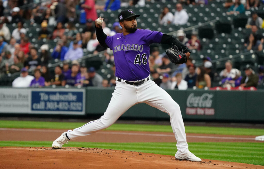 German Marquez pitching on mound in Colorado Rockies purple jersey during intense baseball game Wallpaper