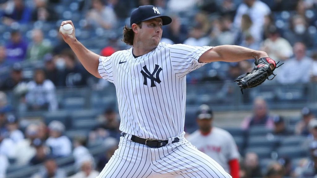 Gerrit Cole mid-pitch in Yankees pinstripes dynamic MLB wallpaper with blurred stadium background