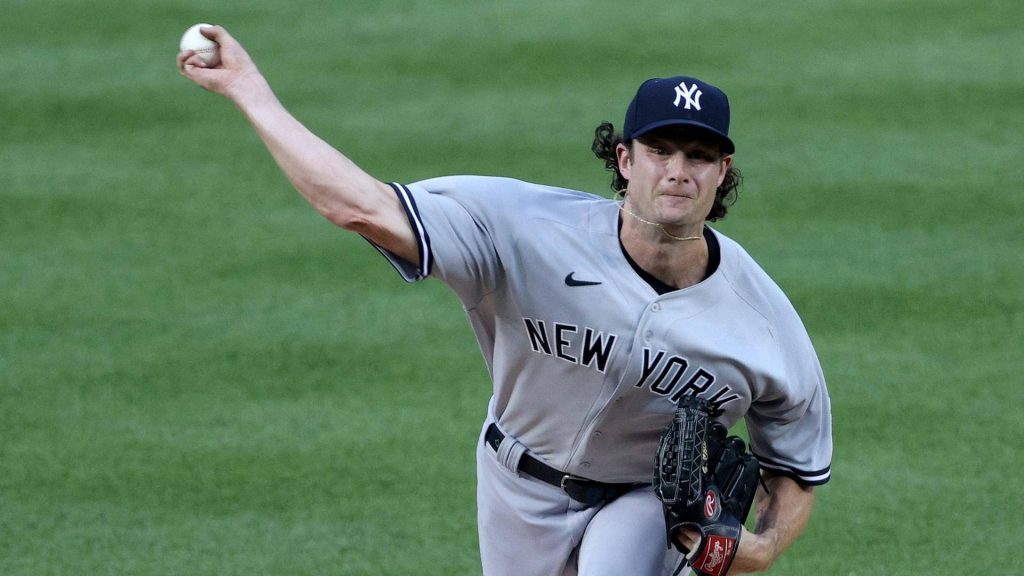 Gerrit Cole pitching for New York Yankees in grey uniform on vibrant green field wallpaper