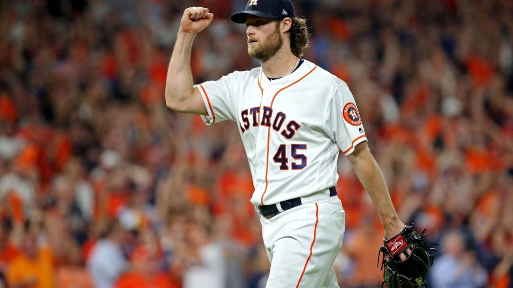MLB pitcher Gerrit Cole in white Astros jersey celebrating with fist pump in vibrant stadium Wallpaper