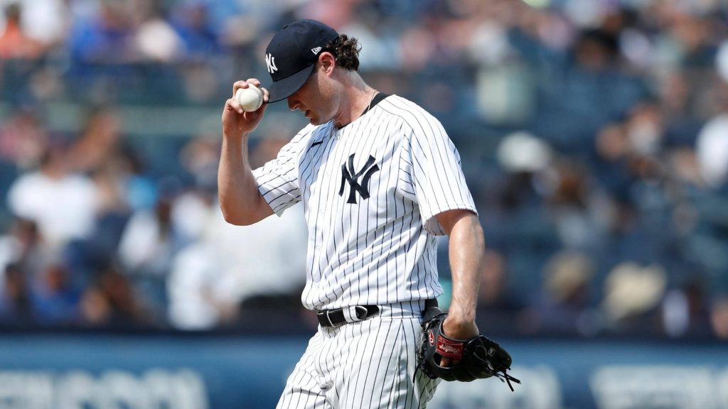Gerrit Cole New York Yankees pitching in pinstripe uniform with baseball and glove on field Wallpaper