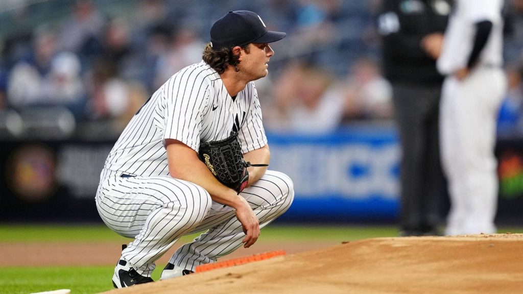 MLB star Gerrit Cole crouching on mound in Yankees pinstripes intense focus wallpaper background