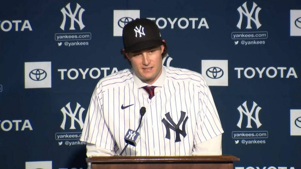 Gerrit Cole Yankees pitcher in pinstriped jersey at press conference with team backdrop wallpaper