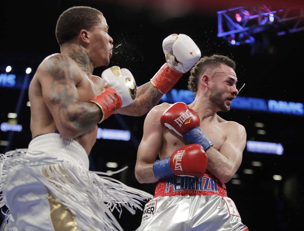 Gervonta Davis delivering powerful punch to Jose Pedraza in intense championship boxing match wallpaper