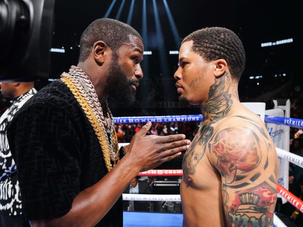 Gervonta Davis and Floyd Mayweather Jr intense boxing faceoff in bright arena lights wallpaper