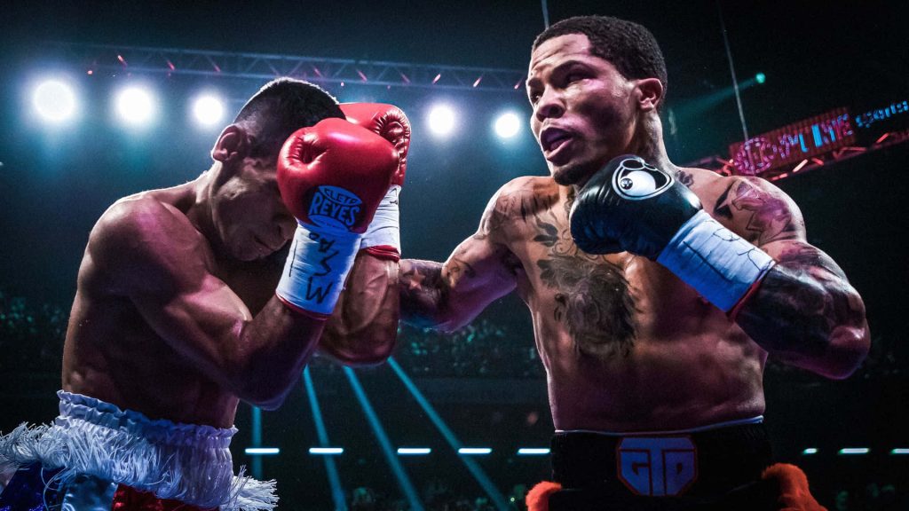 High contrast boxing wallpaper of Gervonta Tank Davis mid-fight under dramatic arena lights