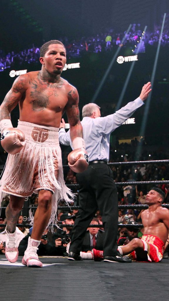 Gervonta Davis walking away after knockdown against Hector Garcia in bright stadium lights Wallpaper