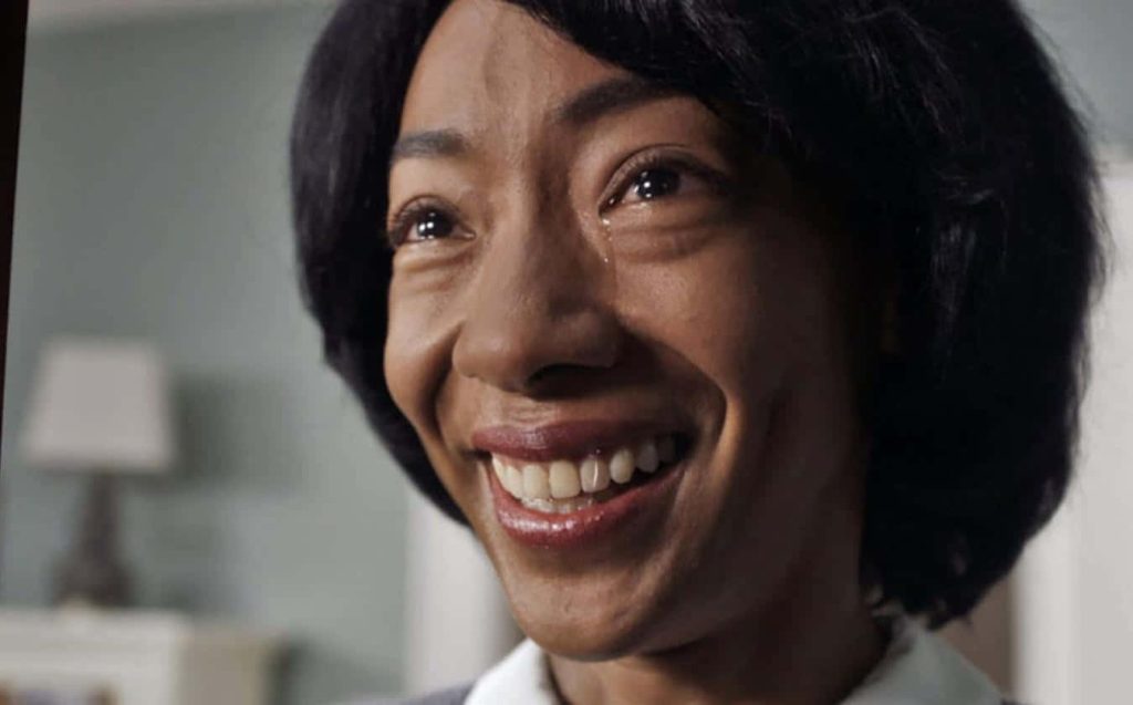 Betty Gabriel as Georgina with forced smile and tear in Jordan Peele Get Out wallpaper