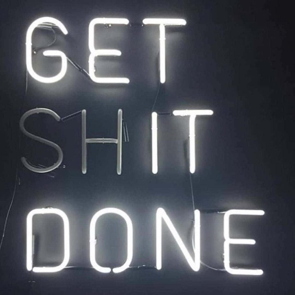 Bold Get Shit Done neon sign glowing white on dark background motivational wallpaper