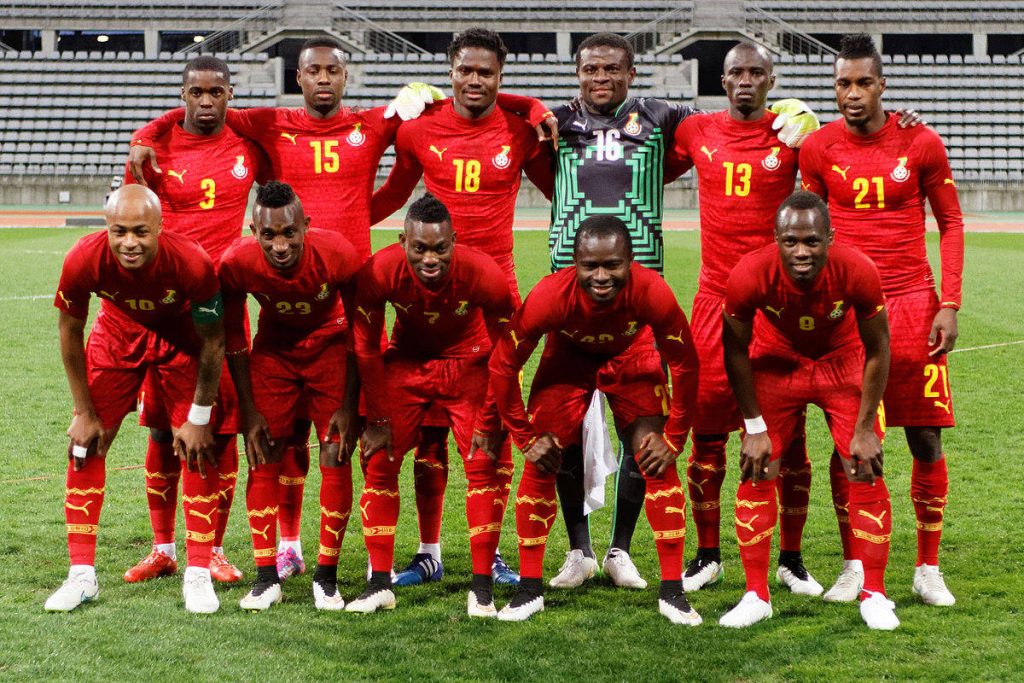 Ghana National Football Team in red kits posing on pitch vibrant high quality wallpaper background