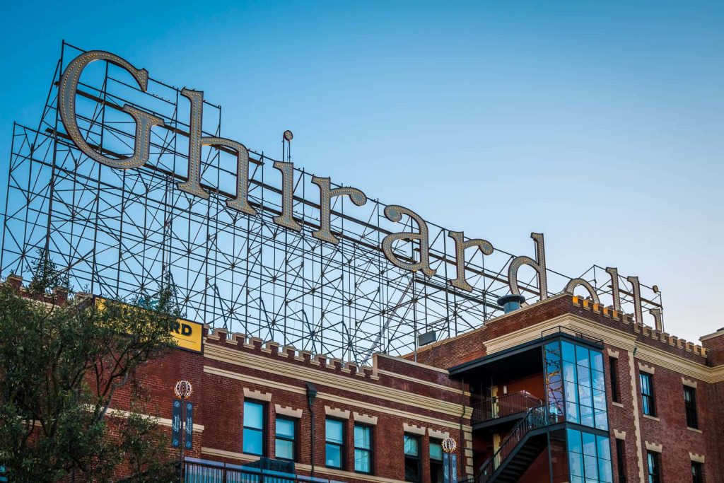 Ghirardelli Square vintage sign on red brick building under clear blue San Francisco sky wallpaper