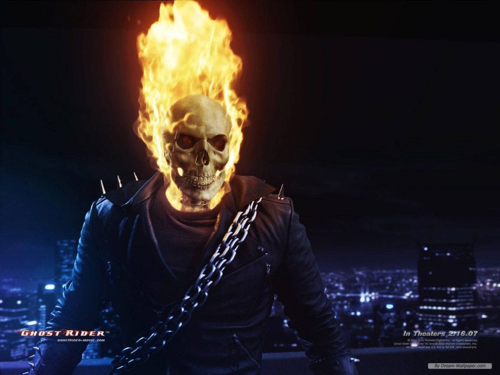 Ghost Rider flaming skull in leather jacket with chains against dark city fire backdrop wallpaper