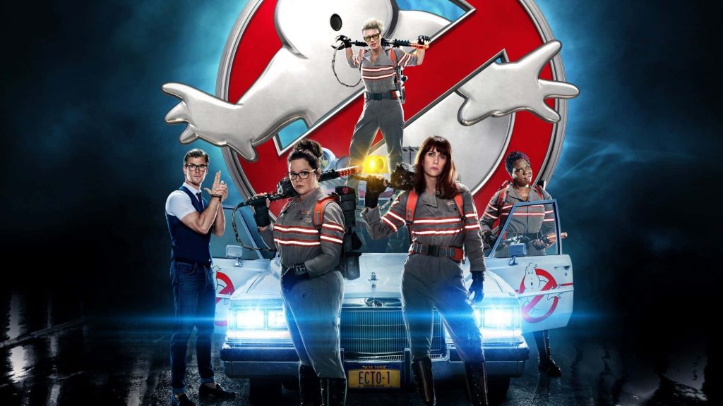 Ghostbusters 2016 cast with proton packs by Ecto-1 and classic logo blue amber lighting wallpaper