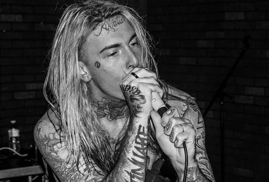 Ghostemane intense black and white performance closeup with tattoos singing into microphone. Wallpaper
