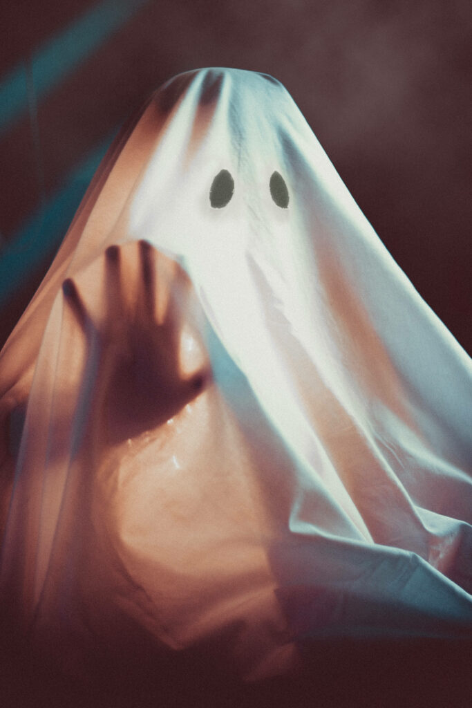Ghostly Encounter: Haunting Halloween Phone Background Illustrates a Mysterious Figure Cloaked in a White Sheet Wallpaper