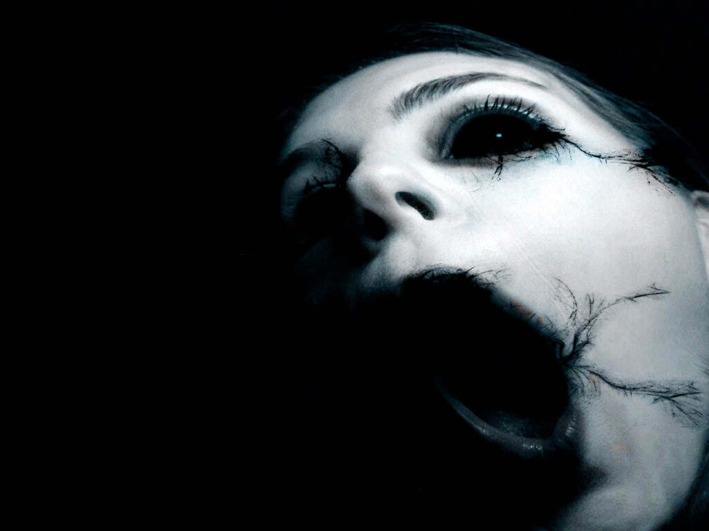 Ghostly face with hollow eyes open mouth eerie shadows cracked textures horror wallpaper background