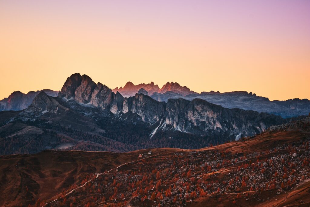 Sunset over Giau Pass Italian Alps with dramatic mountain peaks and rolling rocky hills wallpaper