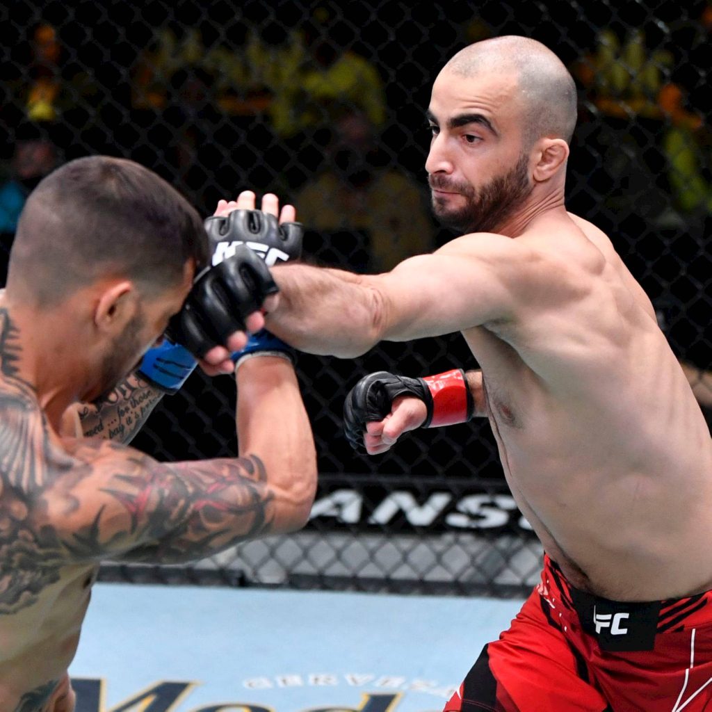 UFC fighter Giga Chikadze delivers a precise strike breaking opponent's defense MMA action Wallpaper