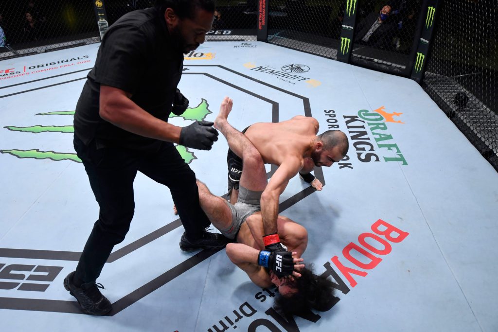 Giga Chikadze delivers TKO strike in intense UFC Octagon MMA fight with referee Herb Dean Wallpaper