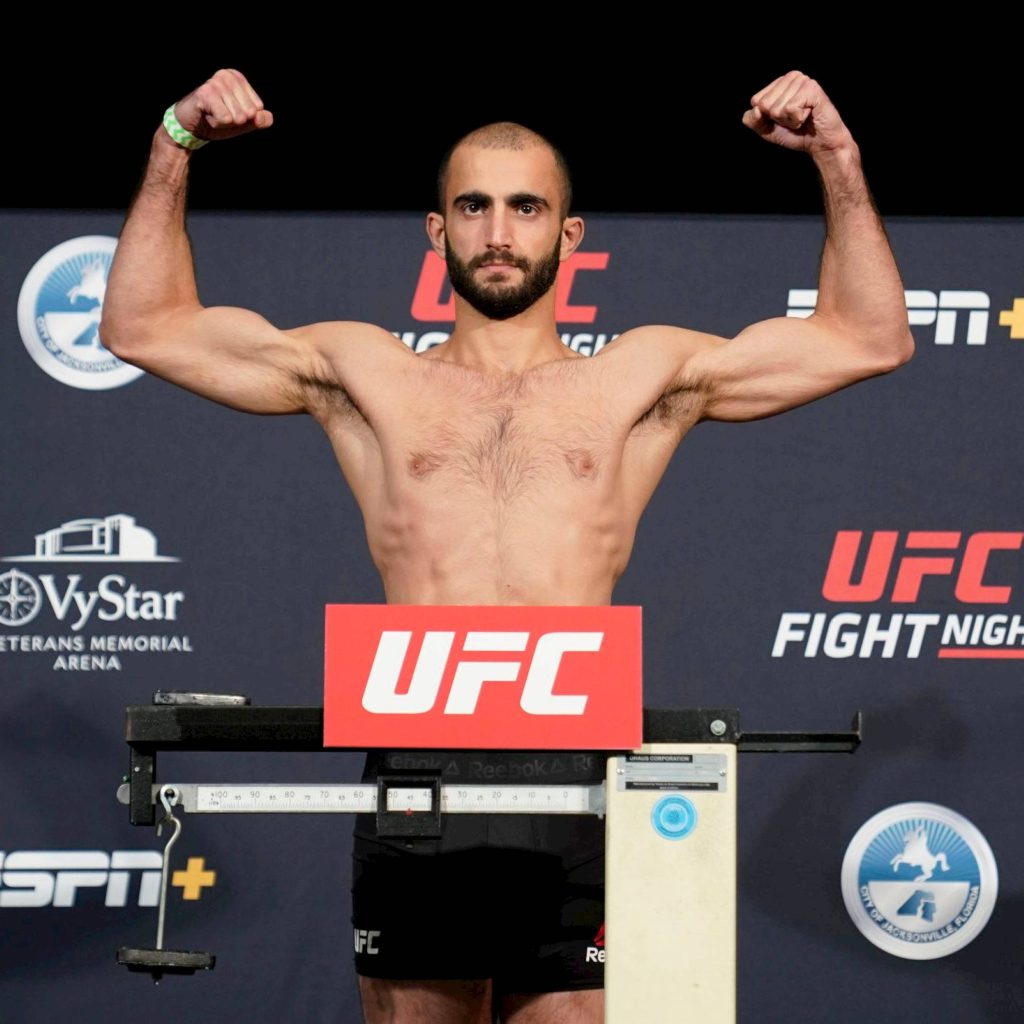 MMA fighter Giga Chikadze flexing muscular physique at UFC official weigh-in event background Wallpaper