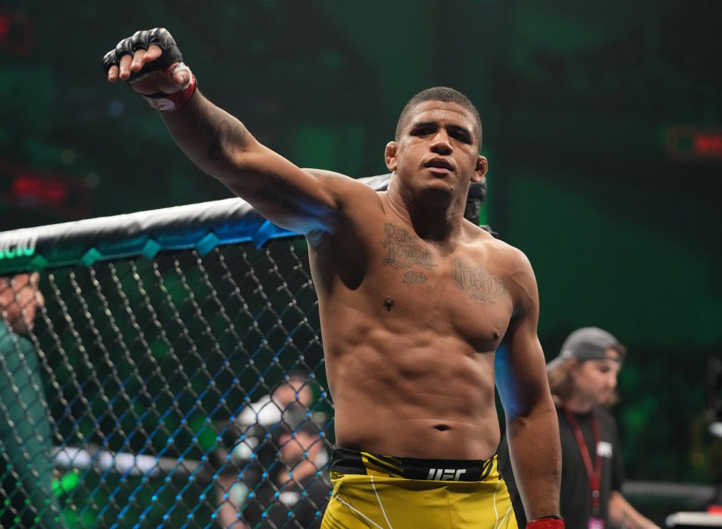 Gilbert Burns UFC fighter celebrating with fist pump in green-lit MMA Octagon arena wallpaper