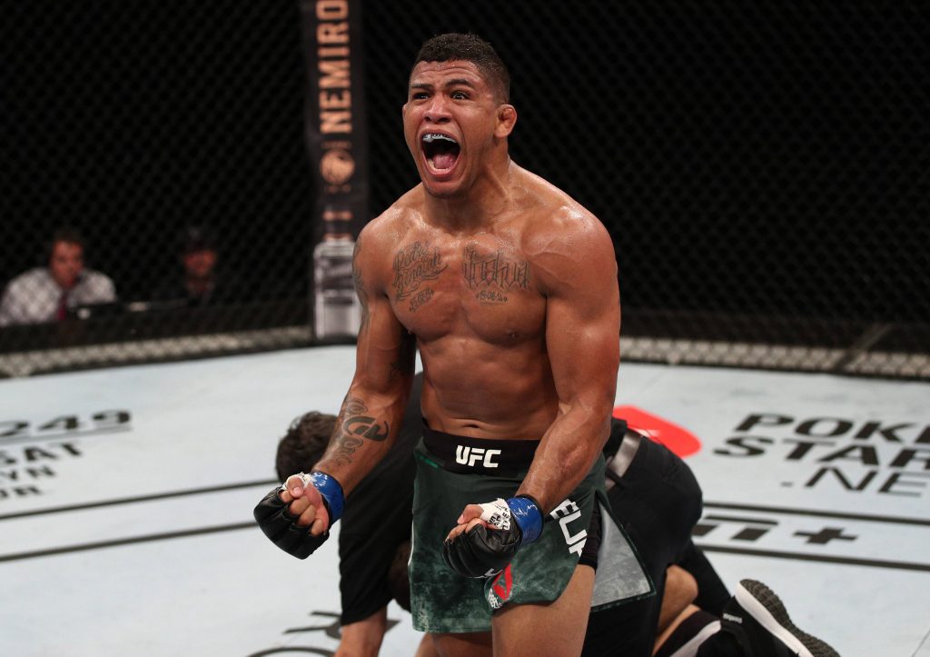 Gilbert Burns roaring in Octagon after UFC victory showcasing tattoos and athletic physique Wallpaper