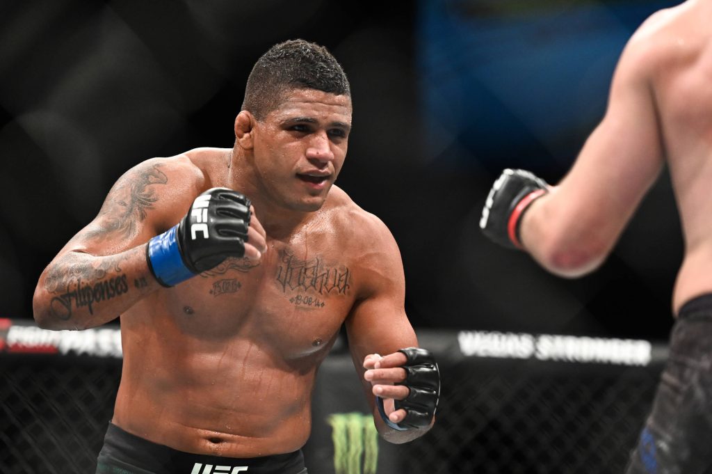 Gilbert Burns UFC wallpaper in Octagon focused stance with tattoos intense MMA action sports background