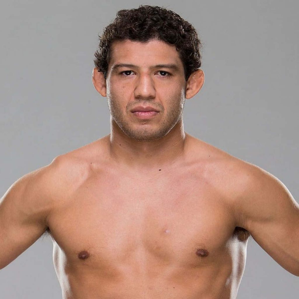Sharp shirtless headshot of UFC fighter Gilbert Melendez with focused gaze on grey background Wallpaper