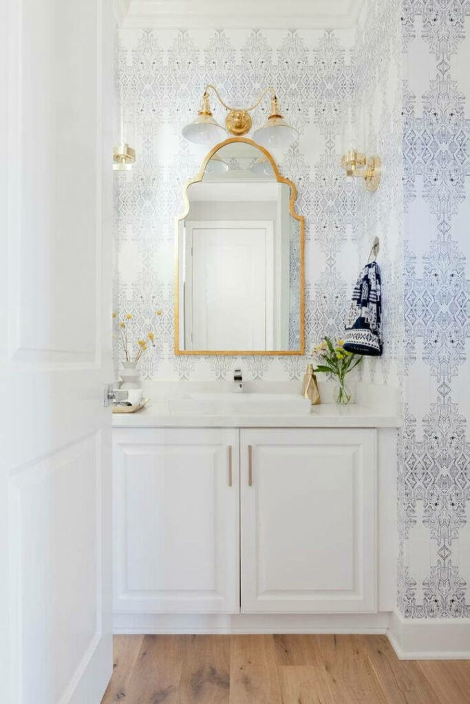 Bohemian Bliss: Captivating Beachside Bathroom featuring a Golden Frame Mirror and Exquisite Wallpaper in the Background
