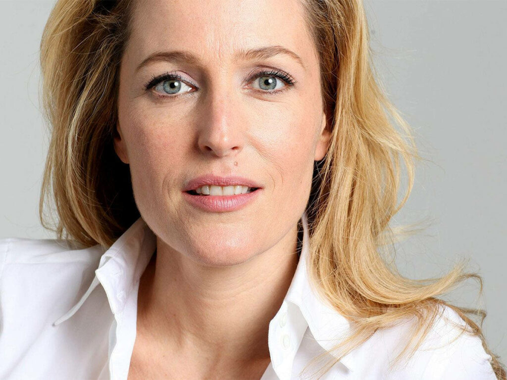 Close-up portrait of Gillian Anderson with soft lighting highlighting her calm confident expression Wallpaper