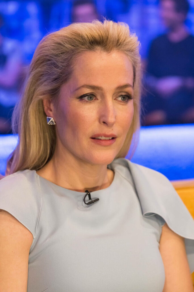 Gillian Anderson poised and elegant close-up on Jonathan Ross Show with soft wallpaper background
