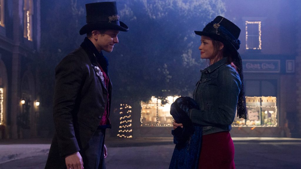 Rory Gilmore and Logan in theatrical costumes on festive Stars Hollow street at night wallpaper