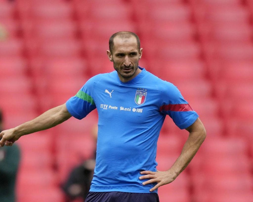 Giorgio Chiellini intense portrait in blue kit with blurred red stadium background wallpaper