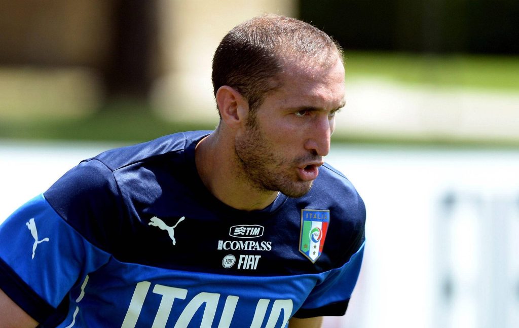 Italian football legend Giorgio Chiellini intense pose in dark blue Italy kit outdoor wallpaper
