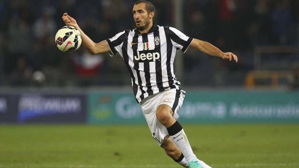 Giorgio Chiellini in Juventus jersey controlling football mid-match dynamic wallpaper background