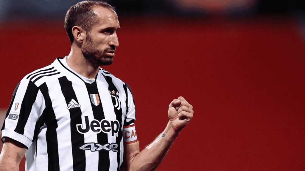 Giorgio Chiellini Juventus kit celebrating with clenched fist red background football passion wallpaper