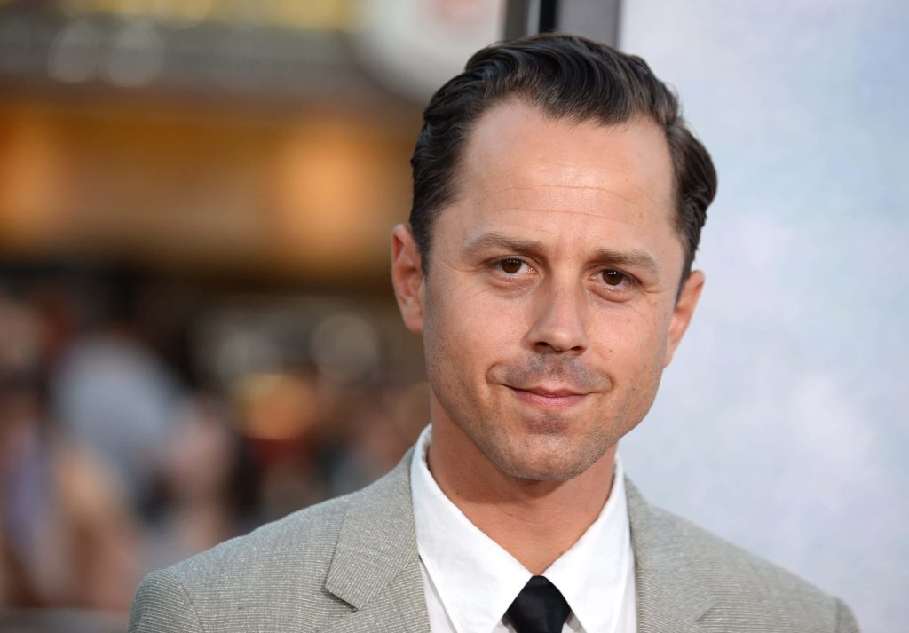 Professional headshot of actor Giovanni Ribisi in light grey suit and black tie with blurred background Wallpaper