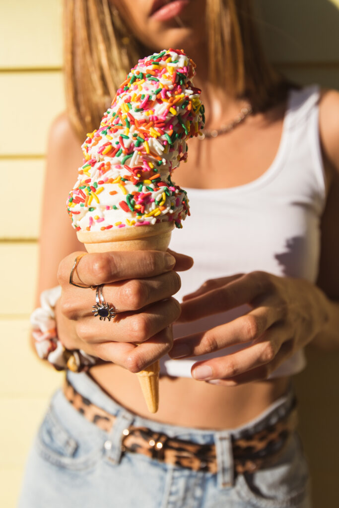 Colorful Ice Cream Cone with Sprinkles: Girl Against Blurred Wallpaper
