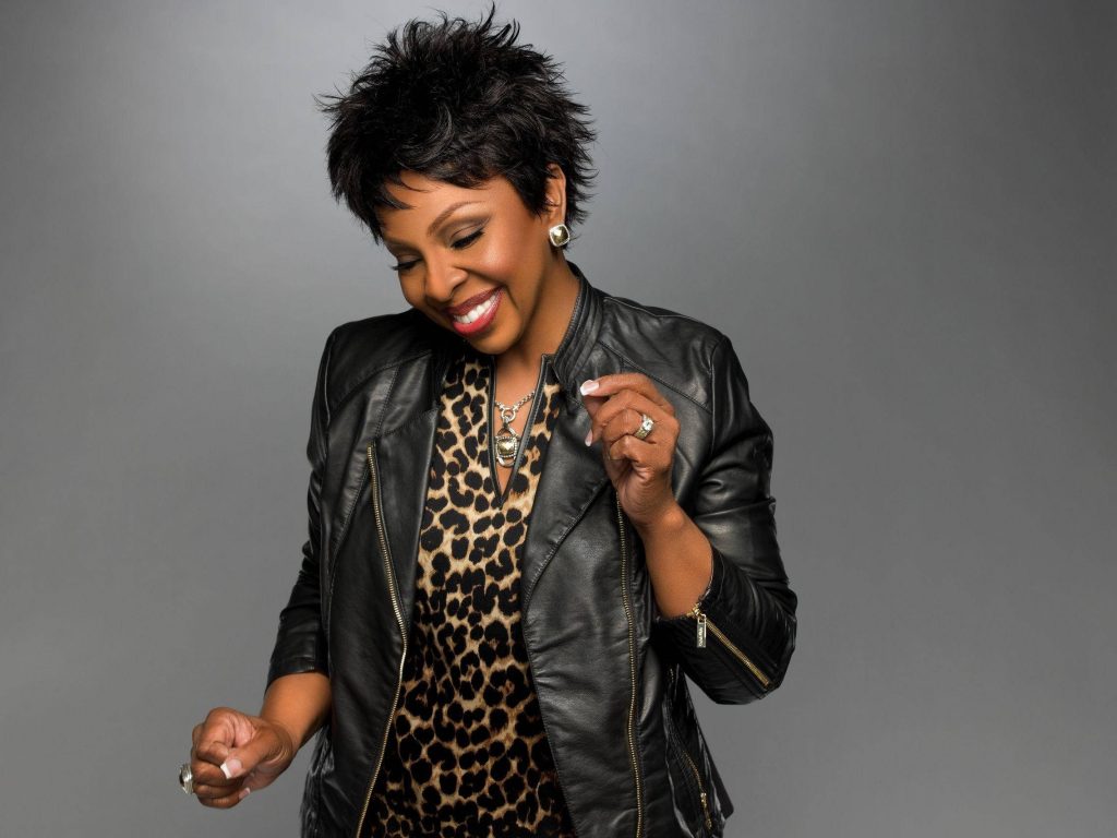 Gladys Knight smiling in black leather jacket and leopard print top studio portrait gray background Wallpaper