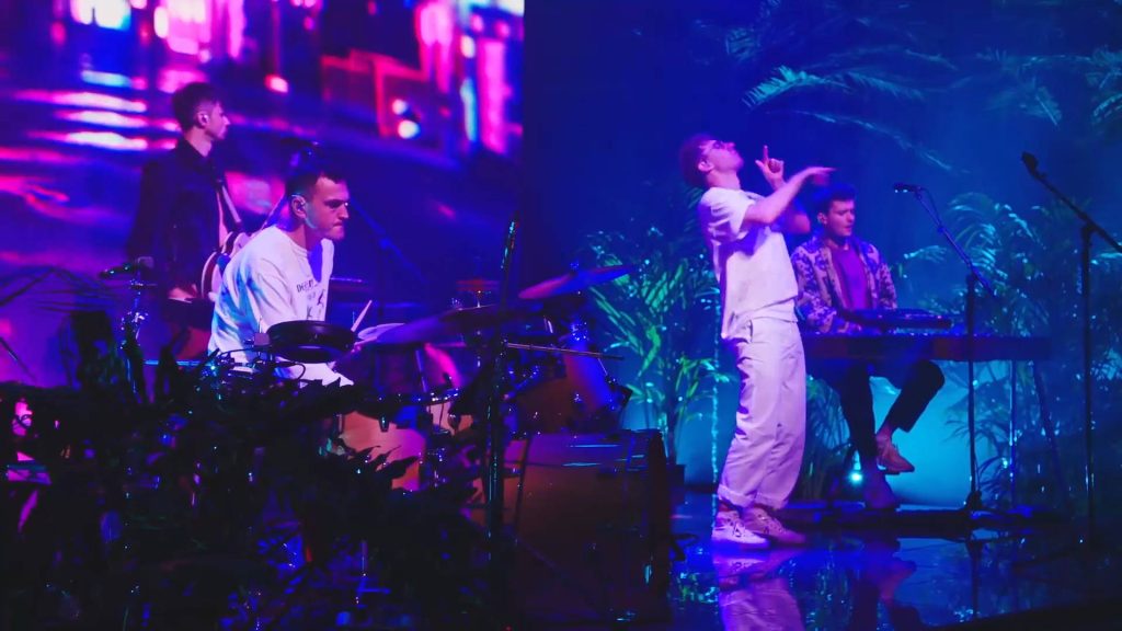Glass Animals live concert with Dave Bayley neon pink blue lights tropical stage wallpaper background