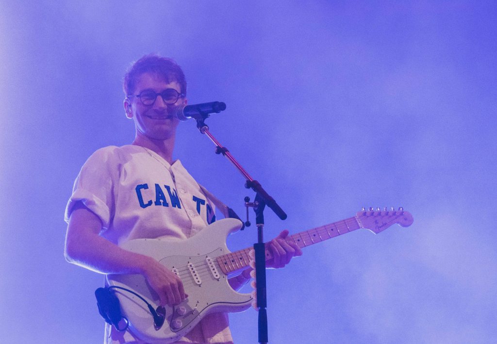 Dave Bayley of Glass Animals plays white guitar on stage in blue lighting live performance wallpaper