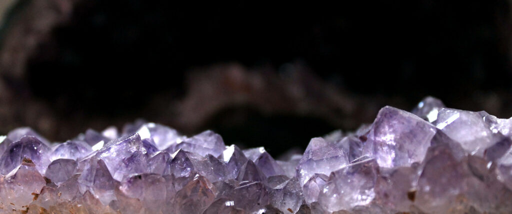 Gleaming jagged amethyst crystals sparkling in sunlight with vivid purple hues and formations Wallpaper