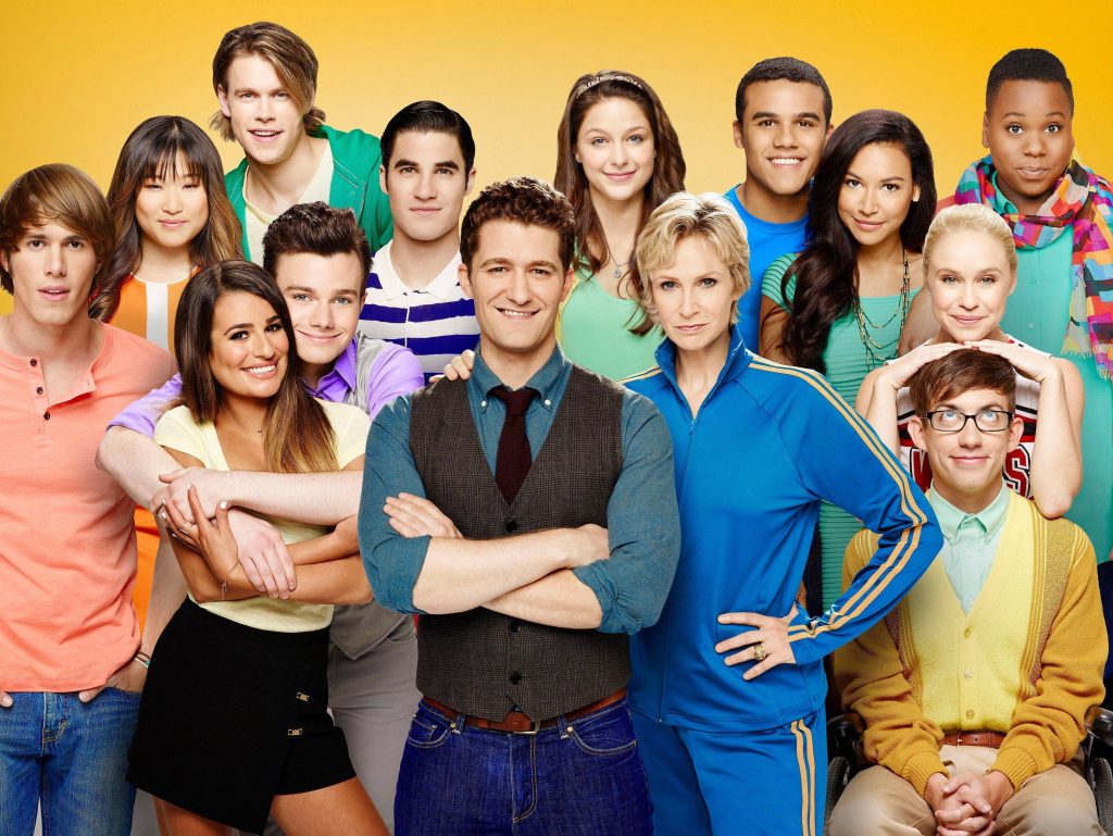 Glee cast vibrant studio portrait with Lea Michele Matthew Morrison Jane Lynch bright yellow background Wallpaper