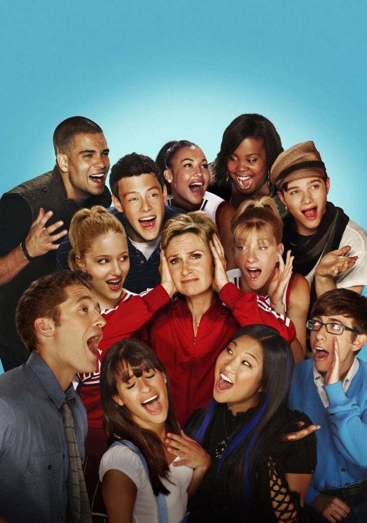 Glee vibrant ensemble cast wallpaper with frustrated Sue Sylvester covering ears playful promo shot