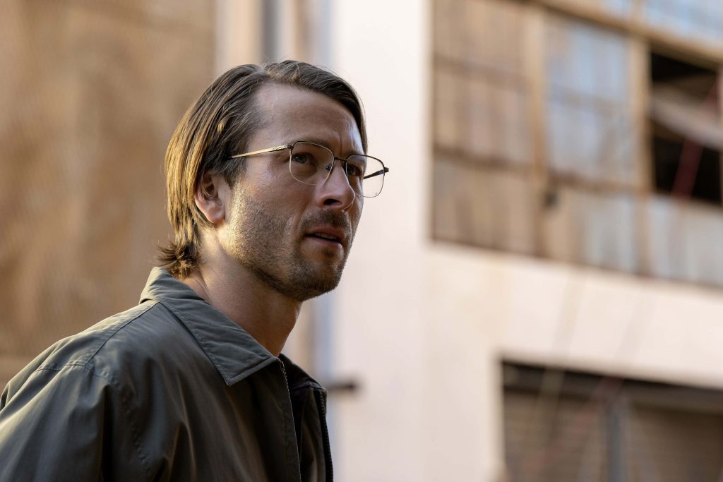 Glen Powell as Gary Johnson Hit Man serious pose wire-rimmed glasses dark jacket film still wallpaper
